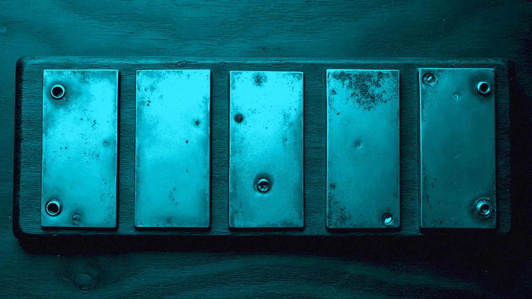 The same strip under the same cyan light, re-cut so the first two plates sit closer together than the last three.